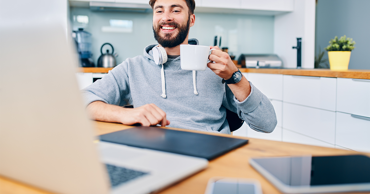 Man with coffee mug looking at a laptop