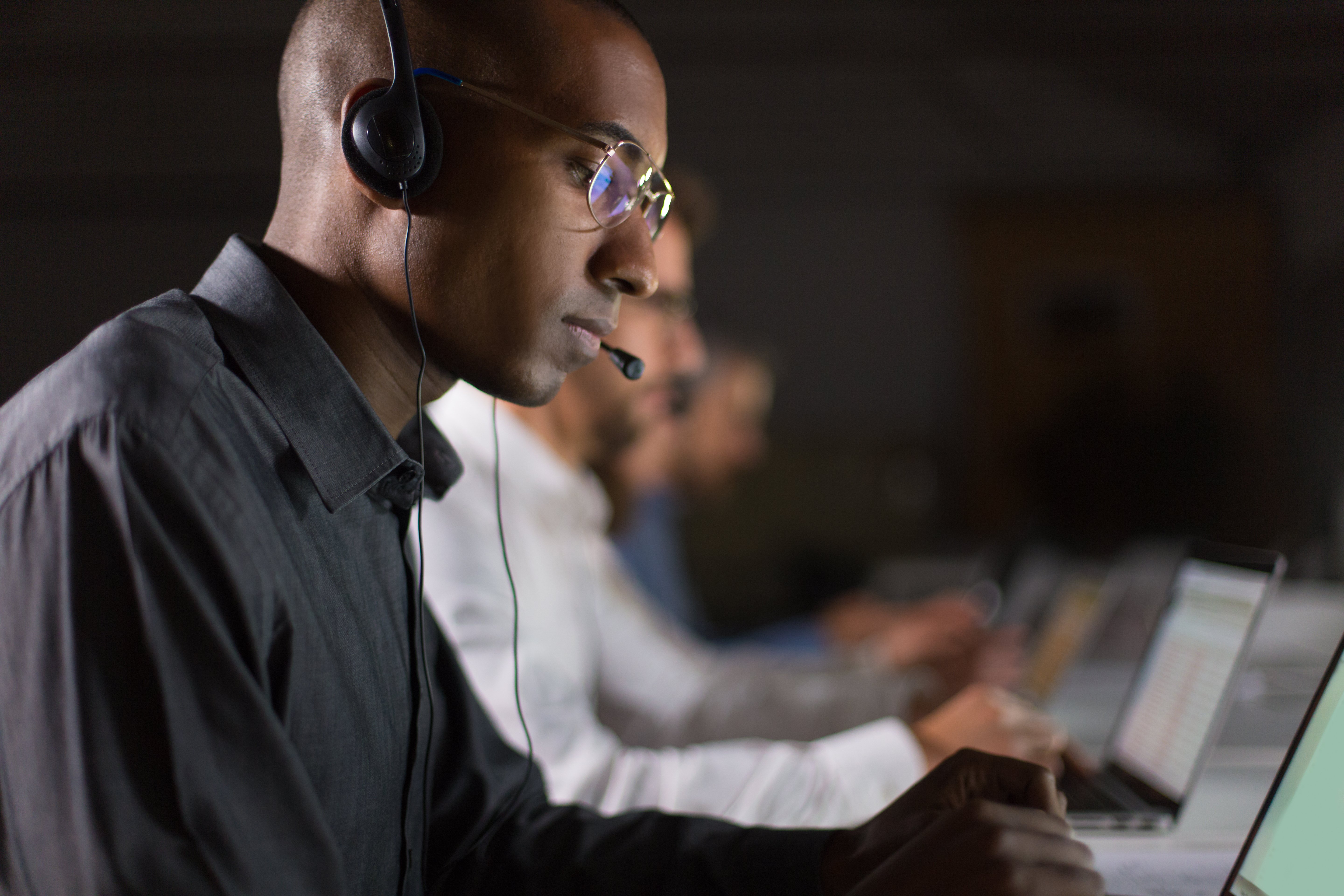 focused-call-center-operator-typing-laptop