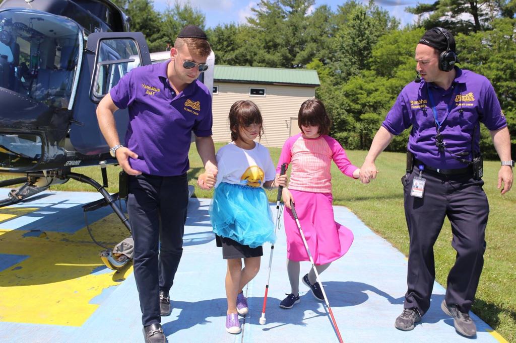 Children with disabilities debarking a helicopter