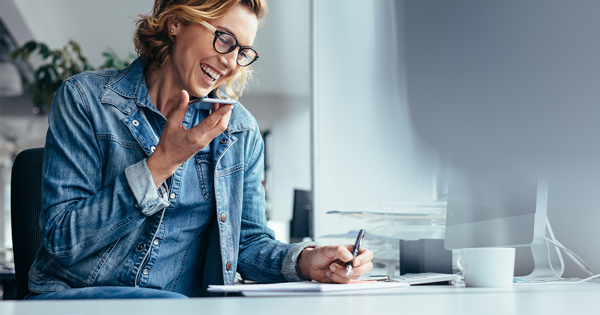 Woman speaking into phone while taking notes